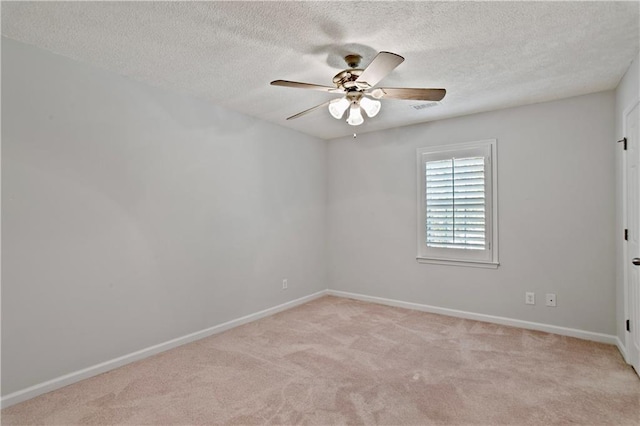 unfurnished room with a textured ceiling, ceiling fan, light colored carpet, and baseboards