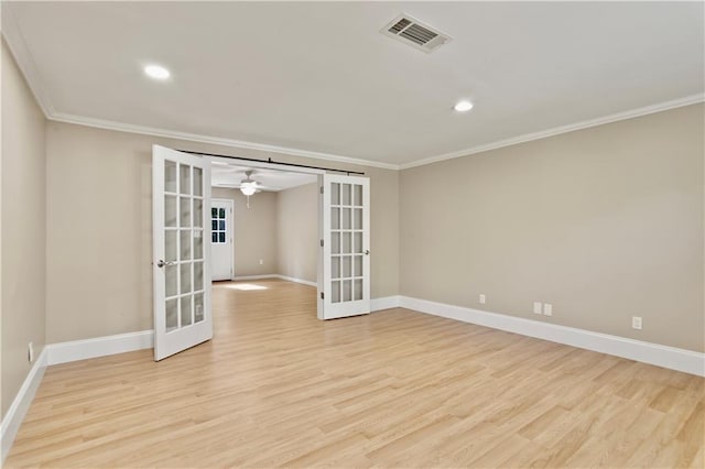 empty room featuring crown molding, visible vents, french doors, and light wood-style floors