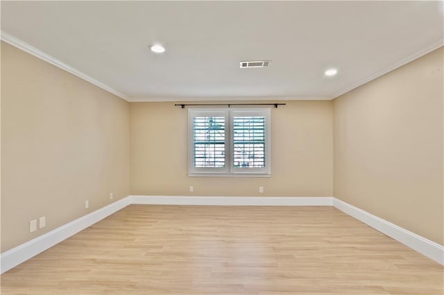 empty room with crown molding, baseboards, light wood-style flooring, and visible vents