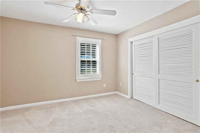 unfurnished bedroom featuring carpet floors, baseboards, ceiling fan, and a closet