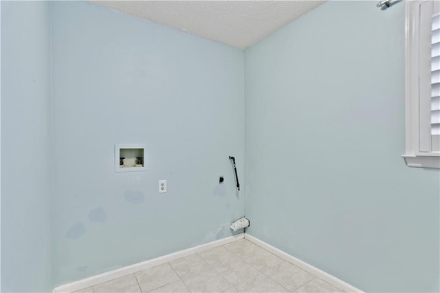 clothes washing area with baseboards, a textured ceiling, laundry area, and washer hookup