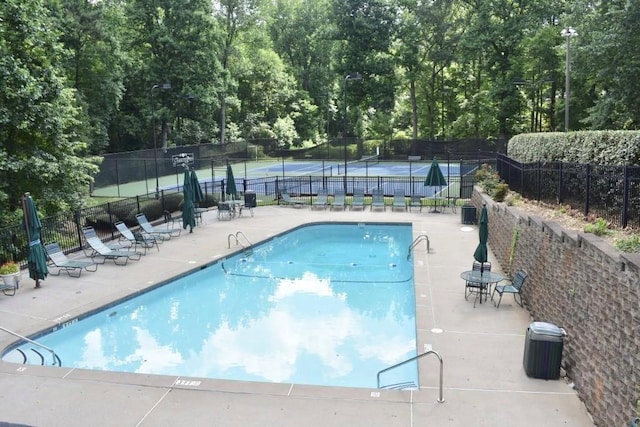 pool featuring fence and a patio area