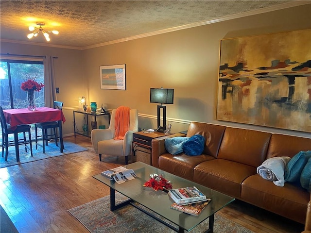 living room featuring crown molding, wood-type flooring, a textured ceiling, and a chandelier