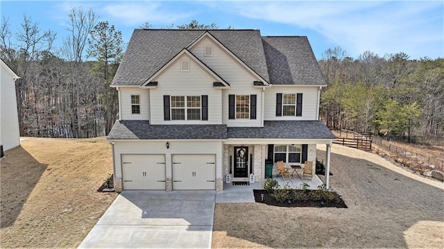 traditional home featuring covered porch, driveway, and a shingled roof