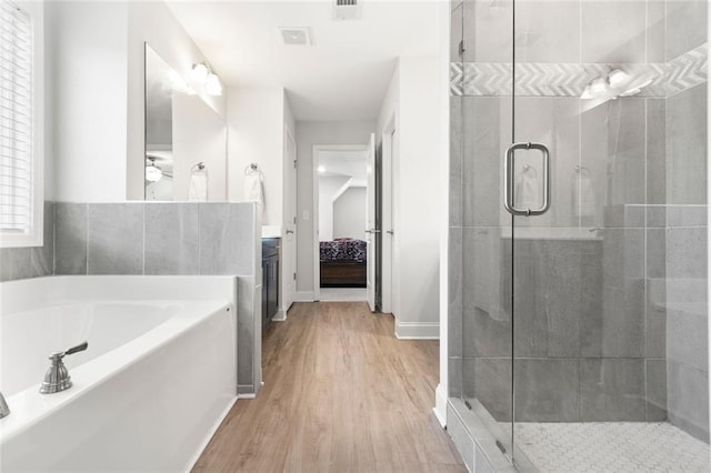 138 Daffodil Lndg, Dallas, GA 30132 - bathroom featuring a garden tub, connected bathroom, a shower stall, wood finished floors, and vanity