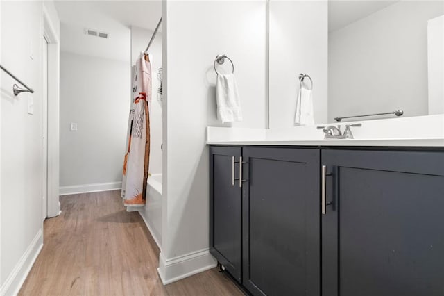 138 Daffodil Lndg, Dallas, GA 30132 - full bath featuring wood finished floors, vanity, shower / bathtub combination with curtain, and baseboards
