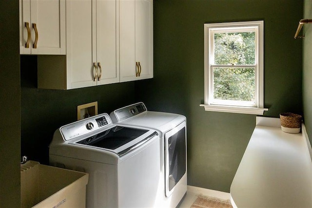 laundry room featuring sink, washer and clothes dryer, and cabinets