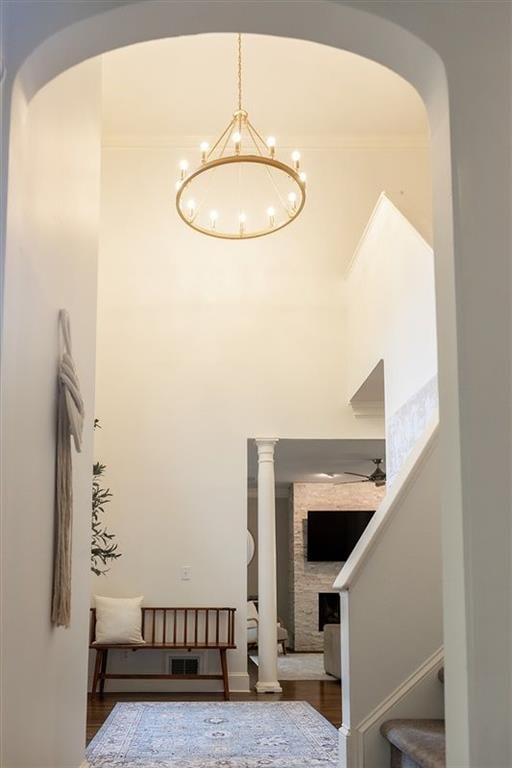 stairs featuring wood-type flooring and ceiling fan with notable chandelier