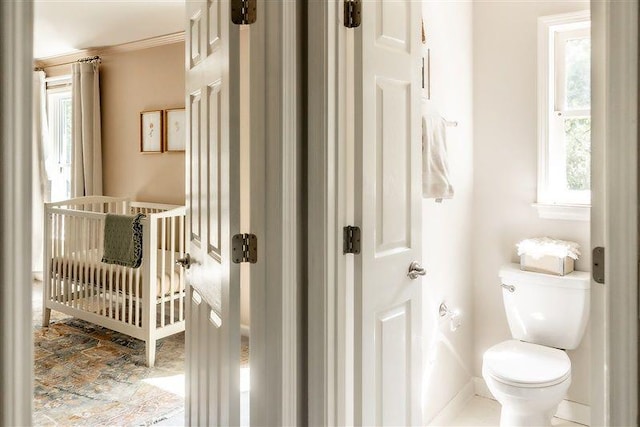 bathroom featuring crown molding and toilet