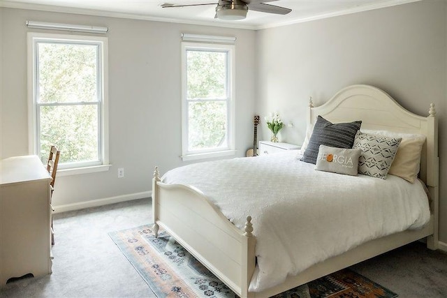 carpeted bedroom featuring multiple windows, ornamental molding, and ceiling fan