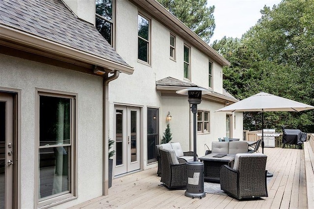 wooden deck with french doors, grilling area, and an outdoor living space with a fire pit