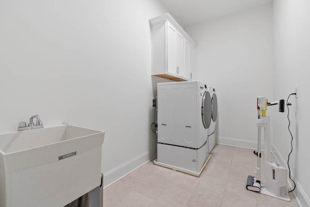3610 Burnt Bridge Rd, Cumming, GA 30028 - laundry area featuring washing machine and dryer, cabinet space, baseboards, and light tile patterned floors