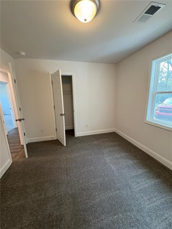 unfurnished bedroom featuring dark colored carpet