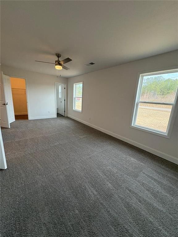 unfurnished room featuring dark colored carpet and ceiling fan