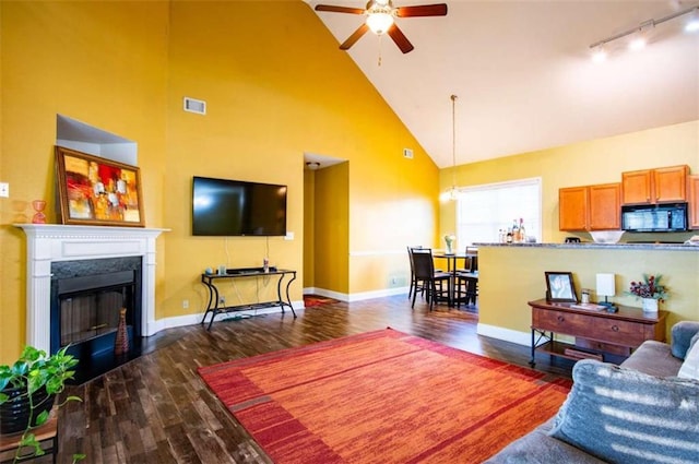 living room with ceiling fan, dark hardwood / wood-style flooring, high vaulted ceiling, and track lighting