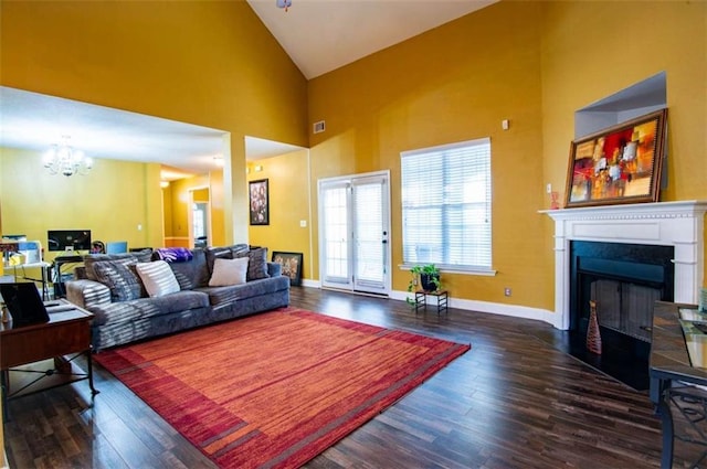 living room featuring dark hardwood / wood-style flooring, high vaulted ceiling, and an inviting chandelier