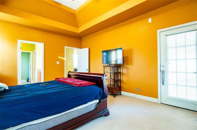 bedroom with carpet flooring, multiple windows, a raised ceiling, and access to outside