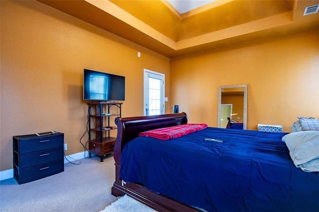 bedroom featuring carpet floors and a tray ceiling