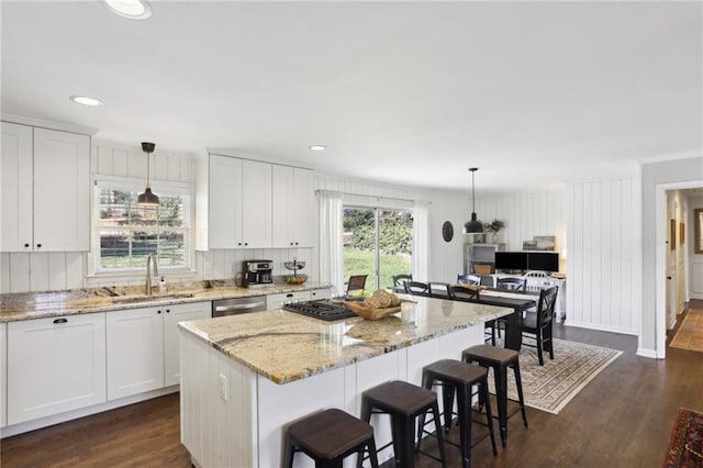 kitchen with white cabinetry, decorative light fixtures, and sink