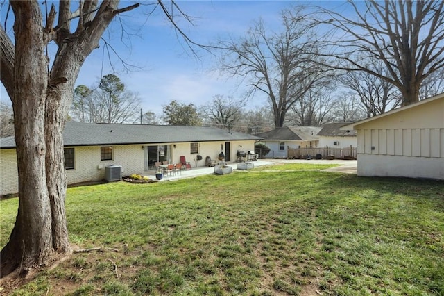 rear view of house featuring central AC unit, a patio, and a lawn