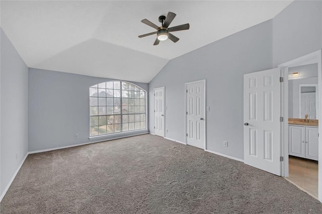 unfurnished bedroom with lofted ceiling, ensuite bath, ceiling fan, and carpet flooring