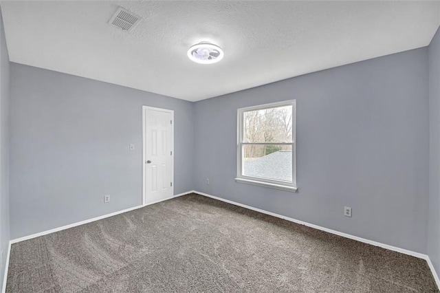 carpeted spare room featuring a textured ceiling