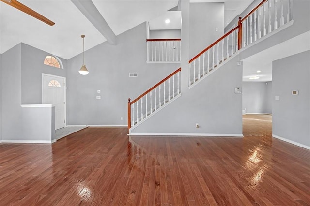 unfurnished living room featuring hardwood / wood-style flooring and high vaulted ceiling