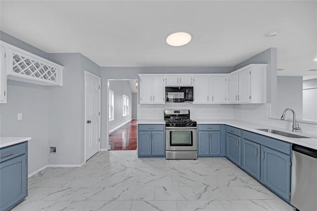 kitchen featuring blue cabinetry, sink, appliances with stainless steel finishes, white cabinets, and backsplash