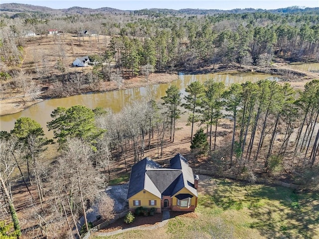 aerial view with a water view and a forest view