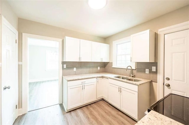 kitchen with decorative backsplash, sink, and white cabinetry