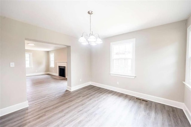 unfurnished dining area with hardwood / wood-style flooring and a notable chandelier