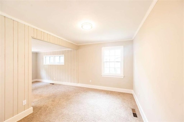 carpeted spare room with a healthy amount of sunlight and crown molding