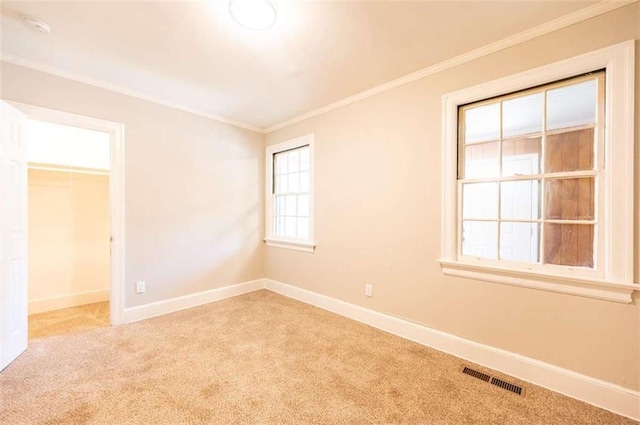 carpeted spare room featuring crown molding