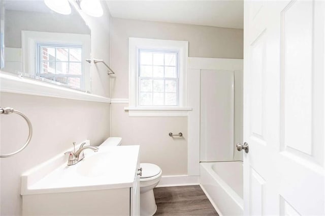 full bathroom featuring hardwood / wood-style floors, toilet, shower / tub combination, and vanity