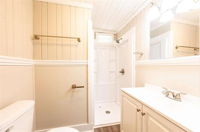 bathroom featuring wood-type flooring, toilet, walk in shower, and vanity