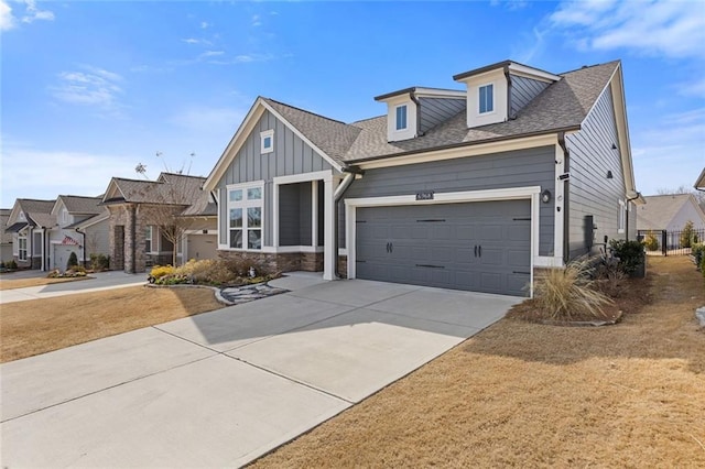 view of front of property featuring a garage, concrete driveway, roof with shingles, a residential view, and board and batten siding