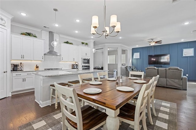 dining room with ceiling fan with notable chandelier, ornamental molding, dark wood-style flooring, and recessed lighting