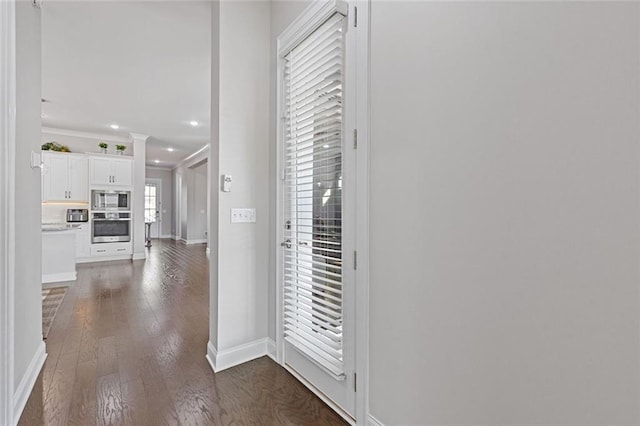 hall with dark wood-style floors, baseboards, crown molding, and recessed lighting