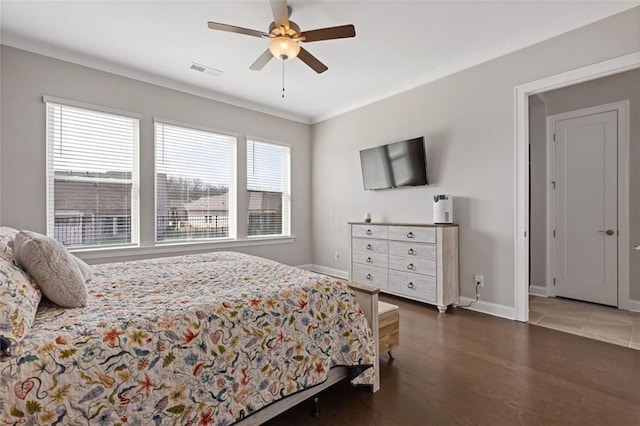 bedroom featuring ornamental molding, wood finished floors, visible vents, and baseboards