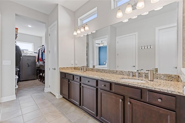 full bathroom with a walk in closet, tile patterned flooring, a sink, and double vanity