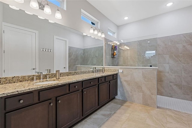 bathroom featuring recessed lighting, double vanity, a sink, and walk in shower