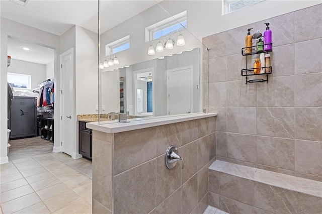 full bath featuring tile patterned floors, a walk in closet, vanity, and a walk in shower