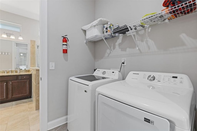 laundry room featuring laundry area, a sink, independent washer and dryer, and baseboards
