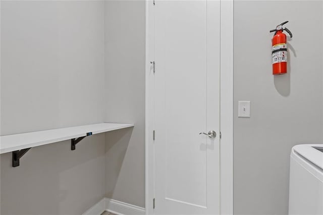 clothes washing area featuring laundry area, washer / dryer, and baseboards