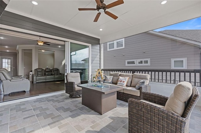 view of patio / terrace with a ceiling fan and an outdoor living space with a fire pit