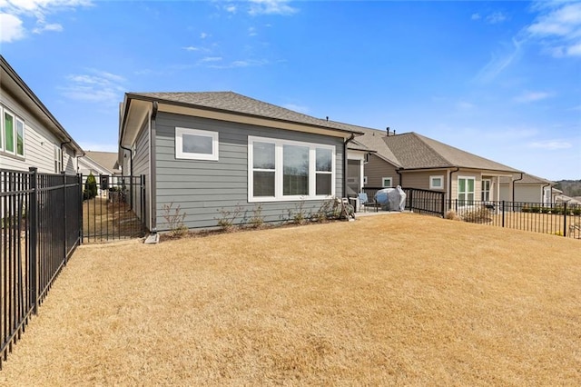 rear view of property featuring a fenced backyard and a yard