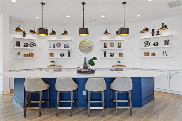 bar with light wood-style flooring, visible vents, backsplash, and recessed lighting