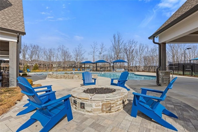 view of patio featuring an outdoor fire pit, fence, a community pool, and a hot tub