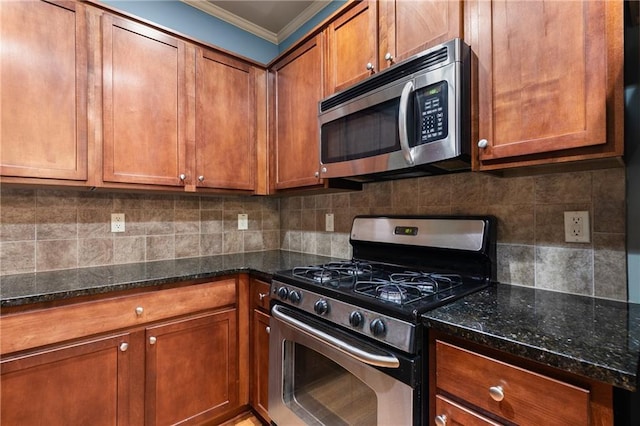 kitchen featuring brown cabinetry, decorative backsplash, stainless steel appliances, and dark stone countertops