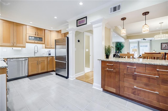 kitchen with light stone counters, stainless steel appliances, a sink, visible vents, and ornate columns